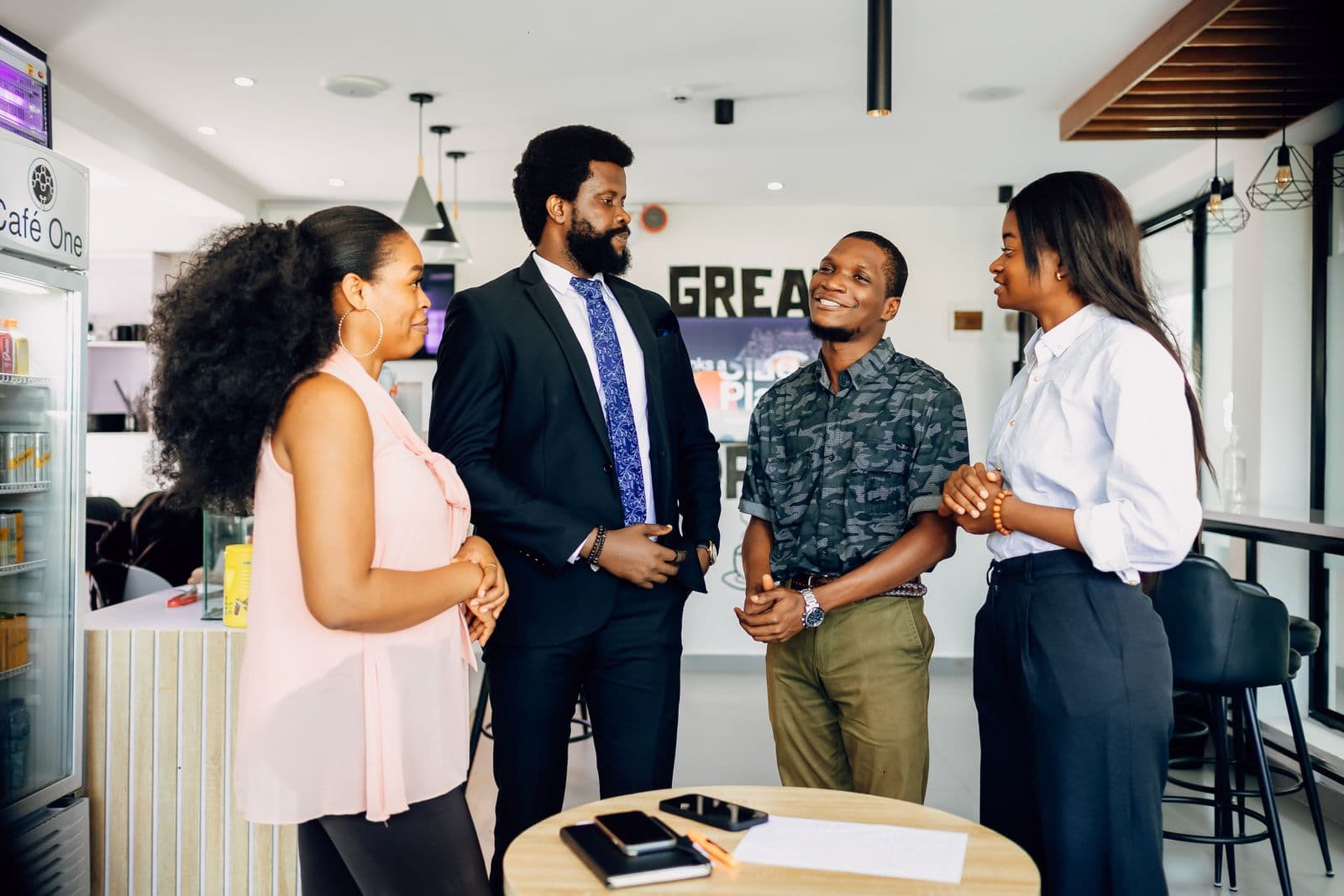 Four colleagues talking together in a modern office reception area