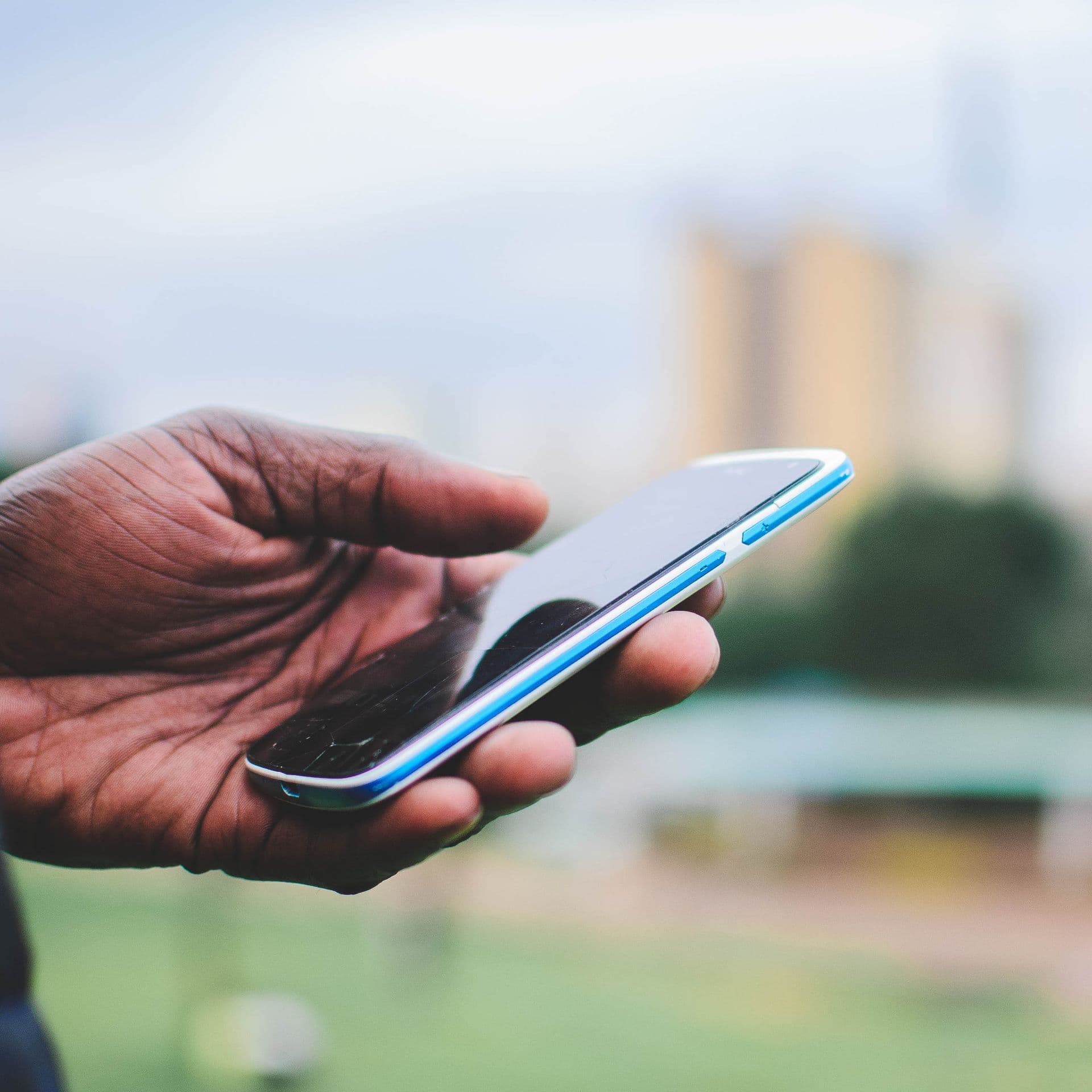 Mobile phone in use against an East African city skyline
